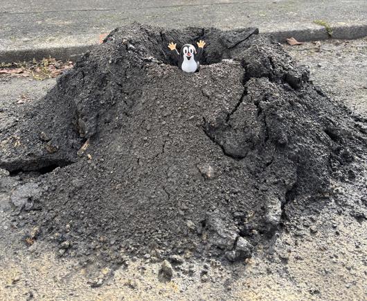 Ein großer Haufen Erde. Darauf steht eine Figur vom kleinen Maulwurf aus der Sendung mit der Maus