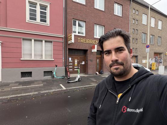 Sascha im Bonn.digital-Hoodie auf der Straße, nasses Haar 🤪