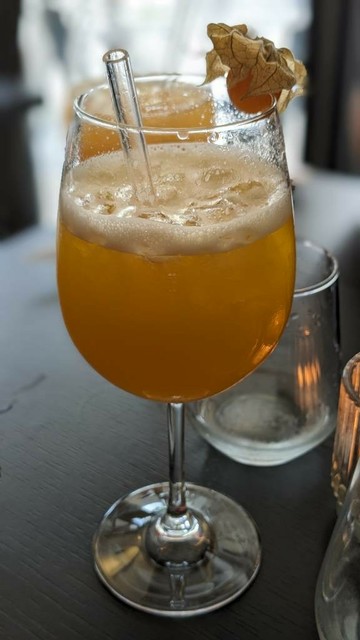 Großes bauchiges Glas mit orangener Flüssigkeit.